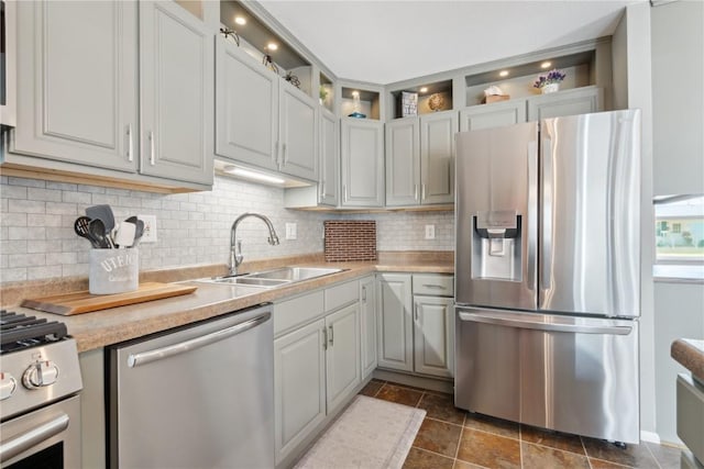 452 Lewellen Dr NW, Cedar Rapids, IA 52405 - kitchen featuring appliances with stainless steel finishes, a sink, decorative backsplash, light countertops, and glass insert cabinets