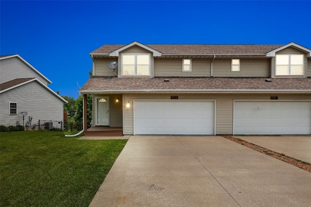 2273 Holiday Rd, Coralville, IA 52241 - view of front of home featuring a front yard, concrete driveway, a shingled roof, a garage, and cooling unit