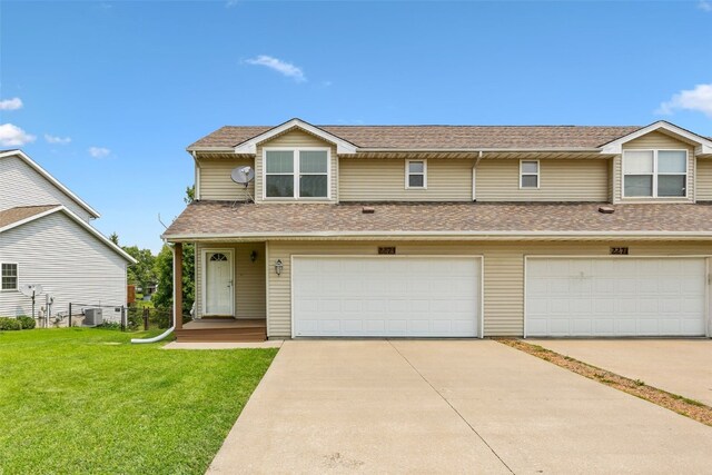 2273 Holiday Rd, Coralville, IA 52241 - view of property with a front lawn, roof with shingles, concrete driveway, and central air condition unit
