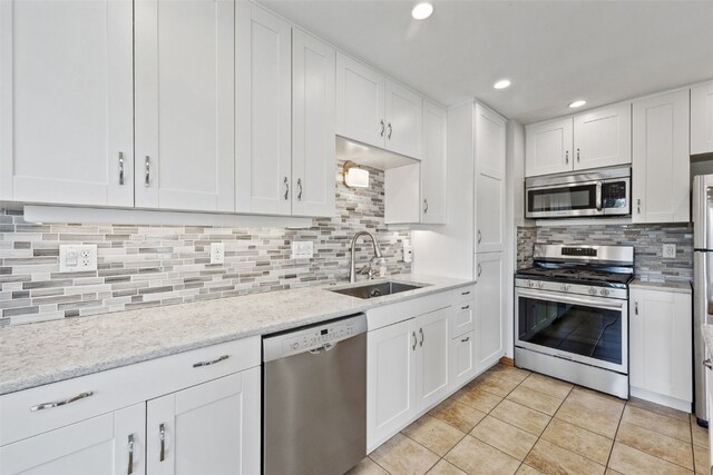 2273 Holiday Rd, Coralville, IA 52241 - kitchen with appliances with stainless steel finishes, a sink, tasteful backsplash, white cabinetry, and recessed lighting