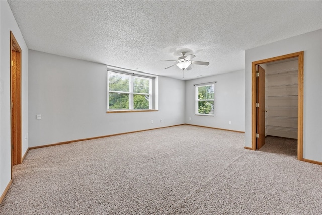 2273 Holiday Rd, Coralville, IA 52241 - unfurnished bedroom with carpet floors, baseboards, ceiling fan, and a textured ceiling