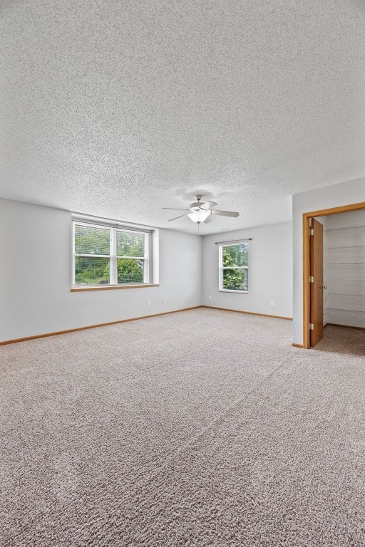 2273 Holiday Rd, Coralville, IA 52241 - carpeted empty room with a ceiling fan, a textured ceiling, and baseboards