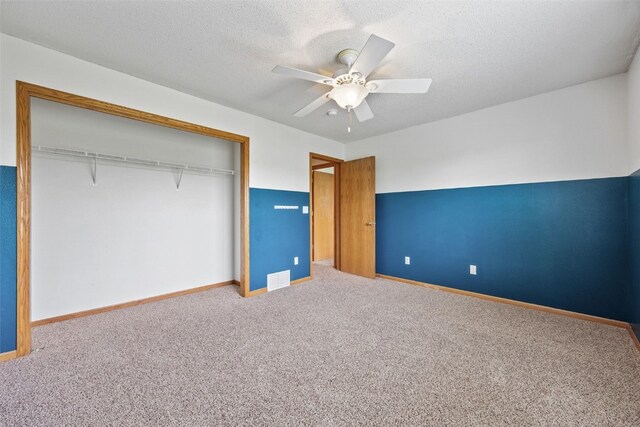 2273 Holiday Rd, Coralville, IA 52241 - unfurnished bedroom with carpet flooring, a closet, baseboards, ceiling fan, and a textured ceiling