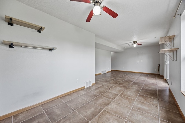 2273 Holiday Rd, Coralville, IA 52241 - tiled empty room with ceiling fan, a textured ceiling, and baseboards