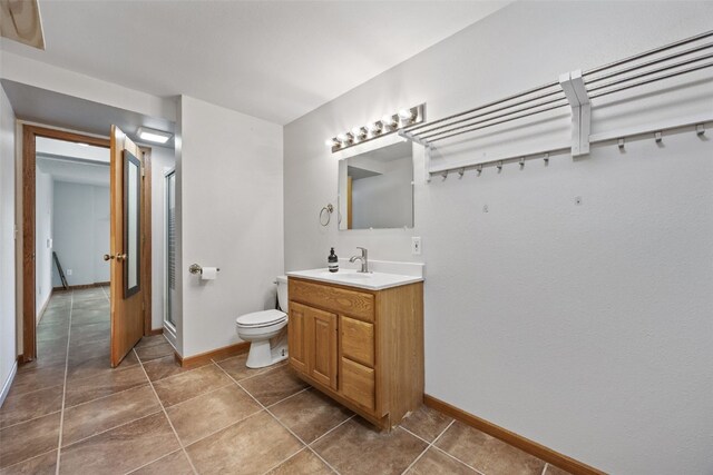 2273 Holiday Rd, Coralville, IA 52241 - bathroom with vanity, baseboards, toilet, tile patterned floors, and a stall shower