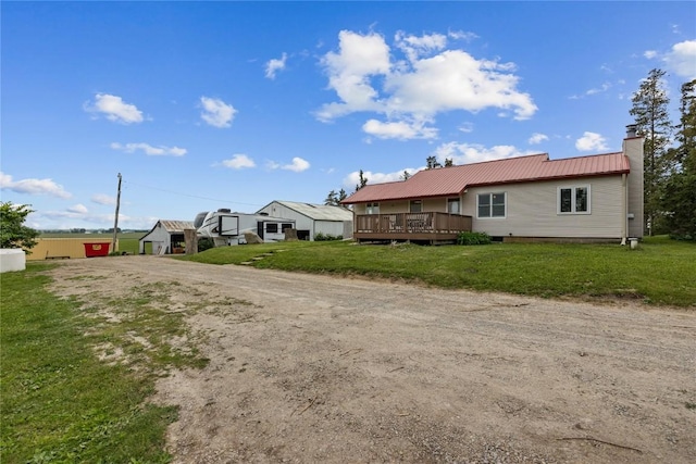 3152 66th St, Shellsburg, IA 52332 - view of front of house with a wooden deck, a chimney, metal roof, dirt driveway, and a front lawn