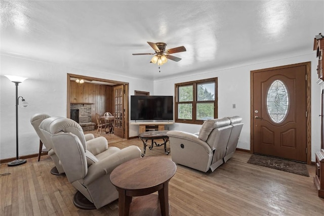 3152 66th St, Shellsburg, IA 52332 - living area featuring ceiling fan, a fireplace, light wood-type flooring, and baseboards