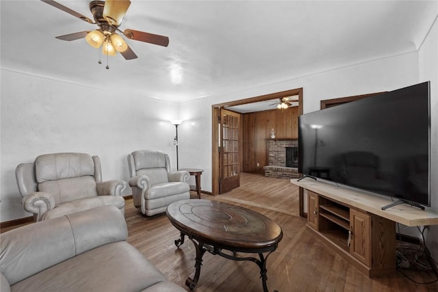 3152 66th St, Shellsburg, IA 52332 - living area featuring a ceiling fan, wood finished floors, a fireplace, and baseboards