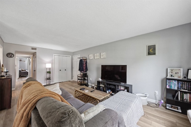 849 Kerry Ln SE Unit 49, Cedar Rapids, IA 52403 - living room featuring light wood finished floors, a textured ceiling, and baseboards