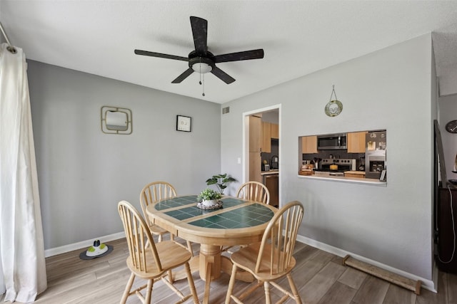 849 Kerry Ln SE Unit 49, Cedar Rapids, IA 52403 - dining room featuring ceiling fan, light wood-style floors, and baseboards