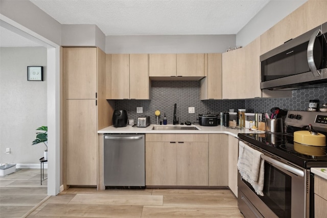 849 Kerry Ln SE Unit 49, Cedar Rapids, IA 52403 - kitchen featuring light brown cabinets, appliances with stainless steel finishes, a sink, light wood-style flooring, and light countertops