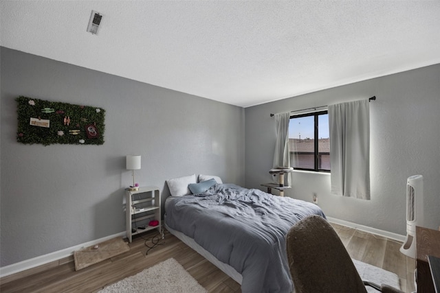 849 Kerry Ln SE Unit 49, Cedar Rapids, IA 52403 - bedroom with wood finished floors, baseboards, and a textured ceiling