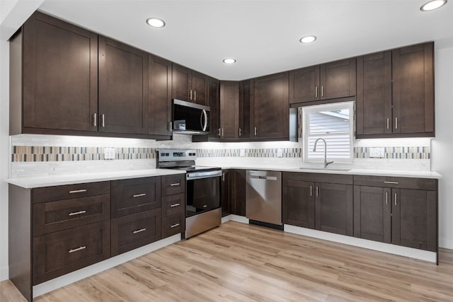 5208 Gordon Ave NW, Cedar Rapids, IA 52405 - kitchen with appliances with stainless steel finishes, a sink, dark brown cabinets, light countertops, and recessed lighting