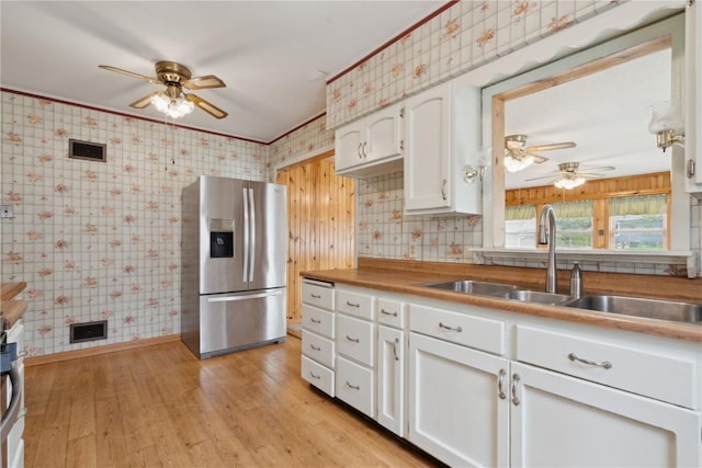 2241 Williams Blvd SW, Cedar Rapids, IA 52404 - kitchen featuring stainless steel refrigerator with ice dispenser, wallpapered walls, ceiling fan, white cabinetry, and a sink