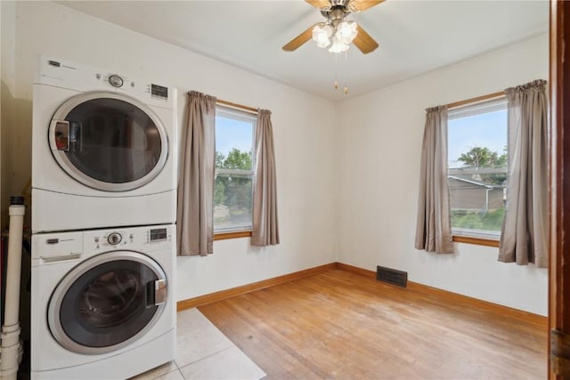 2241 Williams Blvd SW, Cedar Rapids, IA 52404 - laundry room featuring stacked washer and clothes dryer, light wood-style floors, ceiling fan, and baseboards