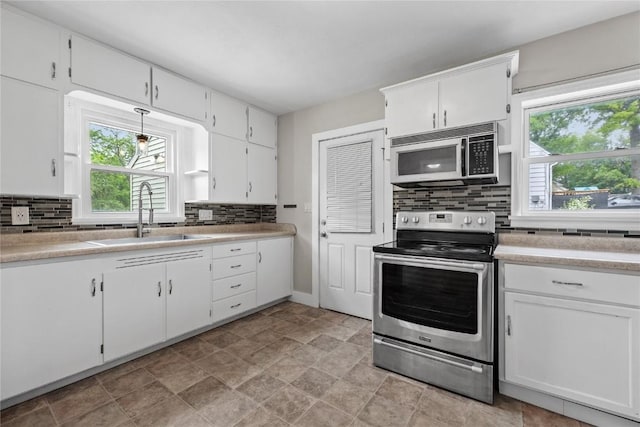 2820 12th Ave SW, Cedar Rapids, IA 52404 - kitchen featuring appliances with stainless steel finishes, a sink, decorative backsplash, light countertops, and white cabinetry