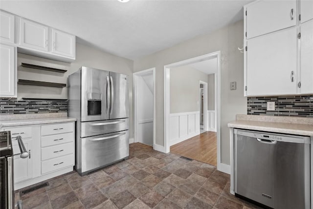 2820 12th Ave SW, Cedar Rapids, IA 52404 - kitchen with stainless steel appliances, stone finish floors, light countertops, white cabinets, and decorative backsplash