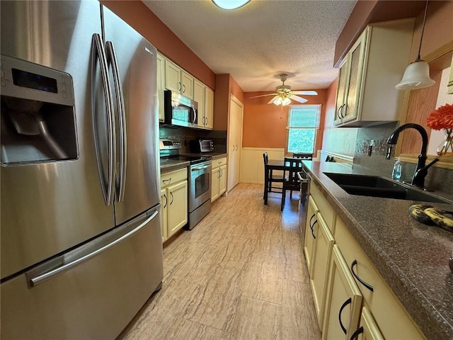 1037 Doubletree Ct NE, Cedar Rapids, IA 52402 - kitchen featuring appliances with stainless steel finishes, a sink, a ceiling fan, dark countertops, and a textured ceiling