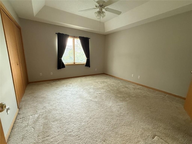 1037 Doubletree Ct NE, Cedar Rapids, IA 52402 - unfurnished bedroom featuring a tray ceiling, light carpet, and baseboards