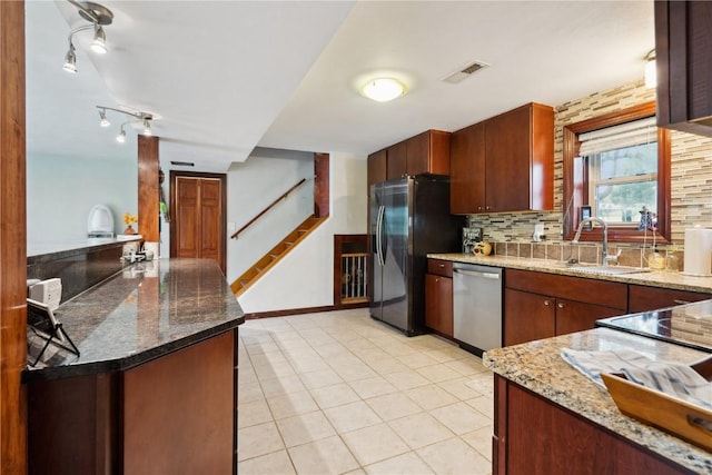 331 Lake View Dr NE, Solon, IA 52333 - kitchen featuring appliances with stainless steel finishes, a sink, light stone countertops, decorative backsplash, and light tile patterned floors