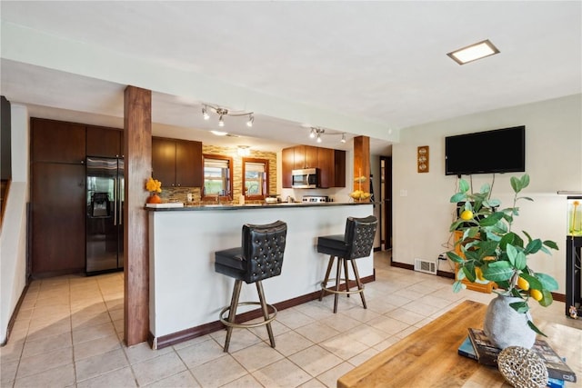 331 Lake View Dr NE, Solon, IA 52333 - kitchen with refrigerator with ice dispenser, stainless steel microwave, light tile patterned floors, and dark countertops