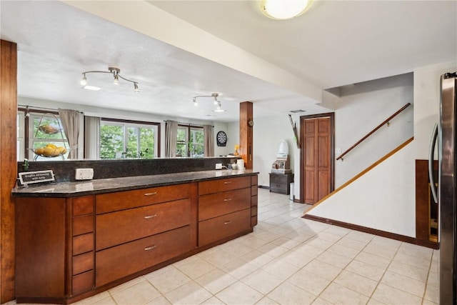331 Lake View Dr NE, Solon, IA 52333 - kitchen featuring freestanding refrigerator, brown cabinets, light tile patterned floors, and baseboards