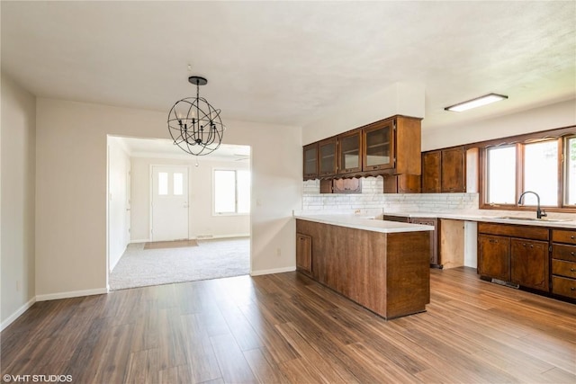 3099 27th Ave, Marion, IA 52302 - kitchen featuring a sink, dark wood-style floors, tasteful backsplash, light countertops, and glass insert cabinets