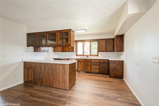 3099 27th Ave, Marion, IA 52302 - kitchen with a sink, decorative backsplash, a peninsula, light countertops, and wood finished floors