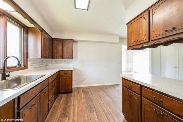 3099 27th Ave, Marion, IA 52302 - kitchen with a sink, light wood-type flooring, baseboards, light countertops, and decorative backsplash