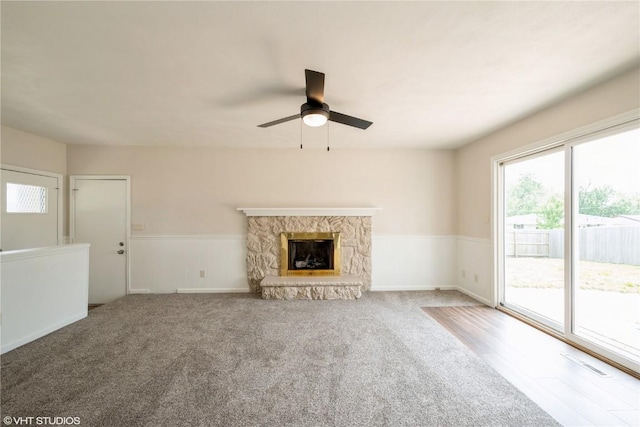 3099 27th Ave, Marion, IA 52302 - unfurnished living room featuring a ceiling fan, a wainscoted wall, a fireplace, and carpet flooring