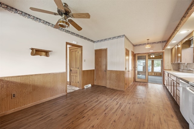 502 5th Ave, Clarence, IA 52216 - kitchen featuring wood-type flooring, a wainscoted wall, a sink, wooden walls, and a ceiling fan