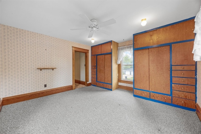 502 5th Ave, Clarence, IA 52216 - unfurnished bedroom featuring two closets, carpet floors, baseboards, wallpapered walls, and ceiling fan