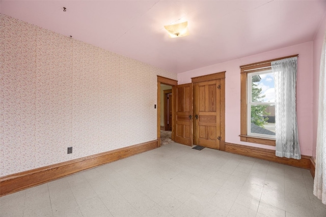 502 5th Ave, Clarence, IA 52216 - spare room with baseboards, tile patterned floors, and wallpapered walls
