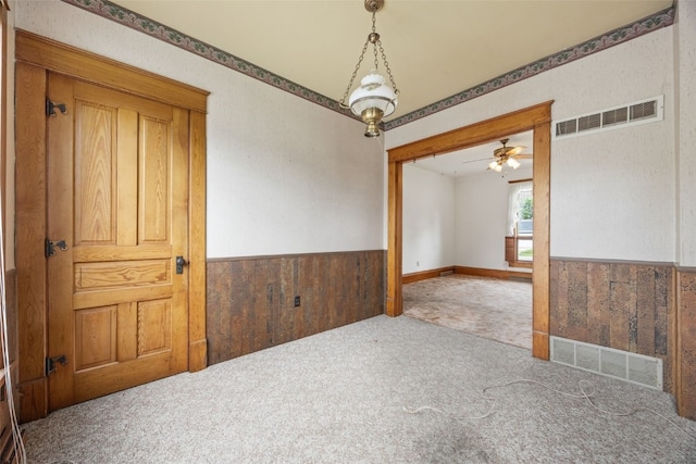 502 5th Ave, Clarence, IA 52216 - empty room featuring carpet, wainscoting, ceiling fan, and wood walls
