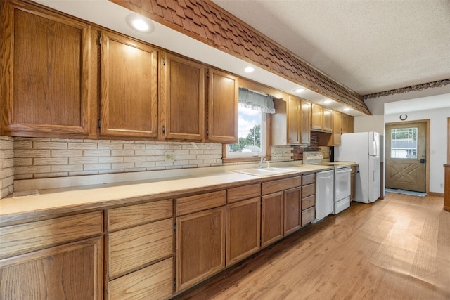 502 5th Ave, Clarence, IA 52216 - kitchen with a sink, white appliances, light countertops, decorative backsplash, and brown cabinets