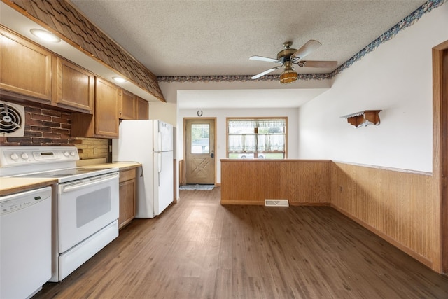 502 5th Ave, Clarence, IA 52216 - kitchen with white appliances, a wainscoted wall, a textured ceiling, a ceiling fan, and wood finished floors