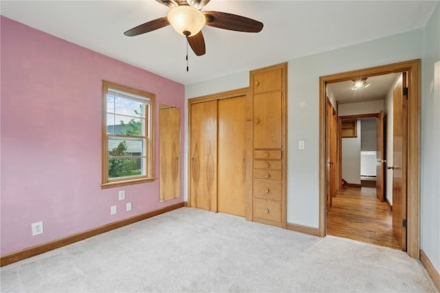 722 47th Ave, Amana, IA 52203 - unfurnished bedroom with baseboards, light colored carpet, a closet, and a ceiling fan