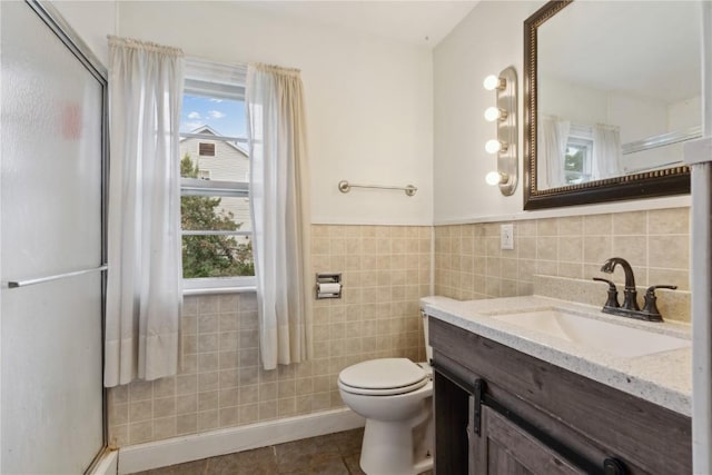 722 47th Ave, Amana, IA 52203 - full bathroom with tile walls, a shower stall, vanity, toilet, and tile patterned floors