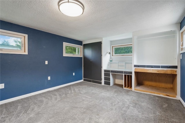 722 47th Ave, Amana, IA 52203 - unfurnished bedroom with a textured ceiling, carpet flooring, and baseboards