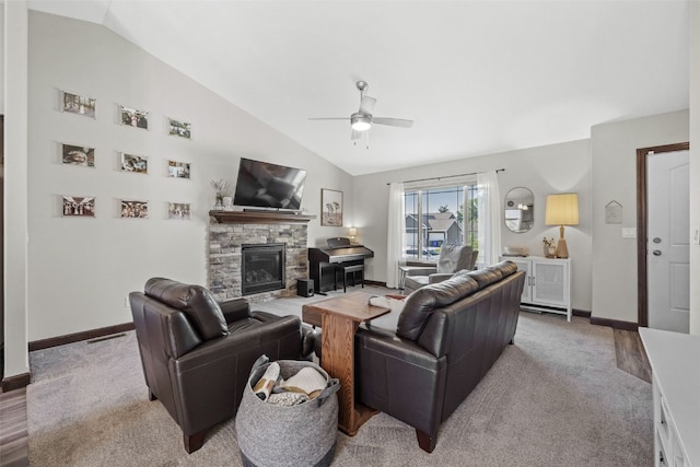 2106 Shady Grove Rd SW, Cedar Rapids, IA 52404 - carpeted living area with vaulted ceiling, a ceiling fan, a stone fireplace, and baseboards