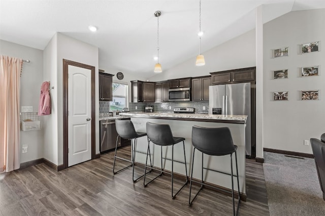 2106 Shady Grove Rd SW, Cedar Rapids, IA 52404 - kitchen featuring appliances with stainless steel finishes, dark brown cabinets, lofted ceiling, backsplash, and a kitchen island