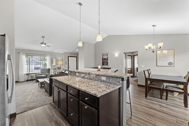2106 Shady Grove Rd SW, Cedar Rapids, IA 52404 - kitchen featuring stainless steel refrigerator with ice dispenser, lofted ceiling, light wood-type flooring, a kitchen bar, and a chandelier