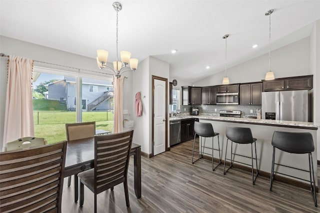 2106 Shady Grove Rd SW, Cedar Rapids, IA 52404 - dining area featuring vaulted ceiling, a chandelier, dark wood-style flooring, and recessed lighting