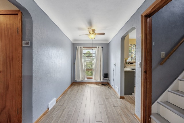 331 36th St NE, Cedar Rapids, IA 52402 - unfurnished room with arched walkways, a textured wall, light wood-style flooring, baseboards, and ceiling fan