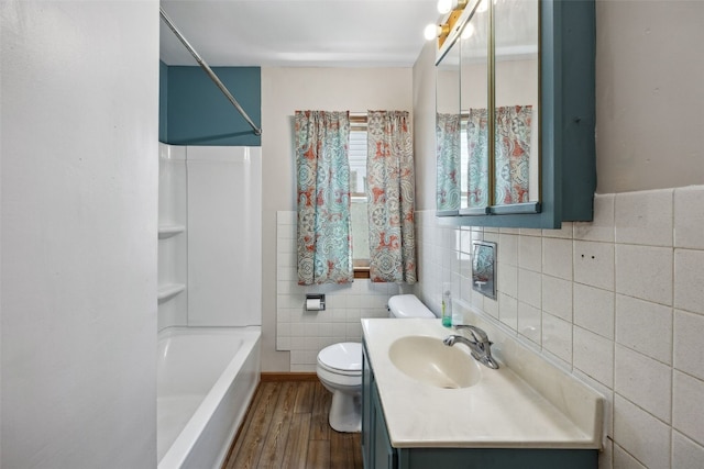 331 36th St NE, Cedar Rapids, IA 52402 - bathroom with tile walls, vanity, toilet, wood finished floors, and shower / washtub combination
