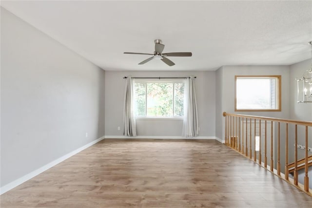 2445 Hillview Dr, Marion, IA 52302 - unfurnished room featuring wood finished floors, a chandelier, a ceiling fan, and baseboards