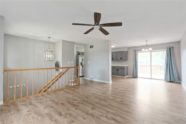 2445 Hillview Dr, Marion, IA 52302 - unfurnished living room featuring a chandelier, light wood-style floors, and baseboards