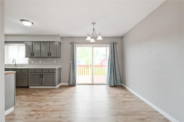 2445 Hillview Dr, Marion, IA 52302 - kitchen with a chandelier, gray cabinets, stainless steel dishwasher, and light wood-style flooring