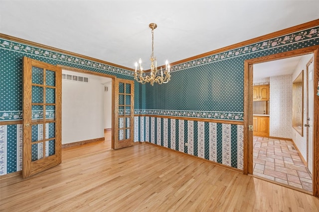 4519 Indian Creek Rd, Marion, IA 52302 - unfurnished room with wallpapered walls, a chandelier, wood finished floors, crown molding, and baseboards