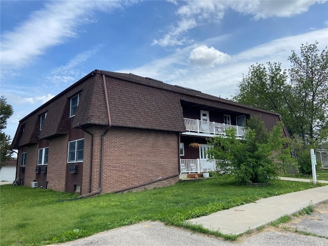 88 1st Ave, Atkins, IA 52206 - view of home's exterior with brick siding, a shingled roof, a lawn, and a balcony